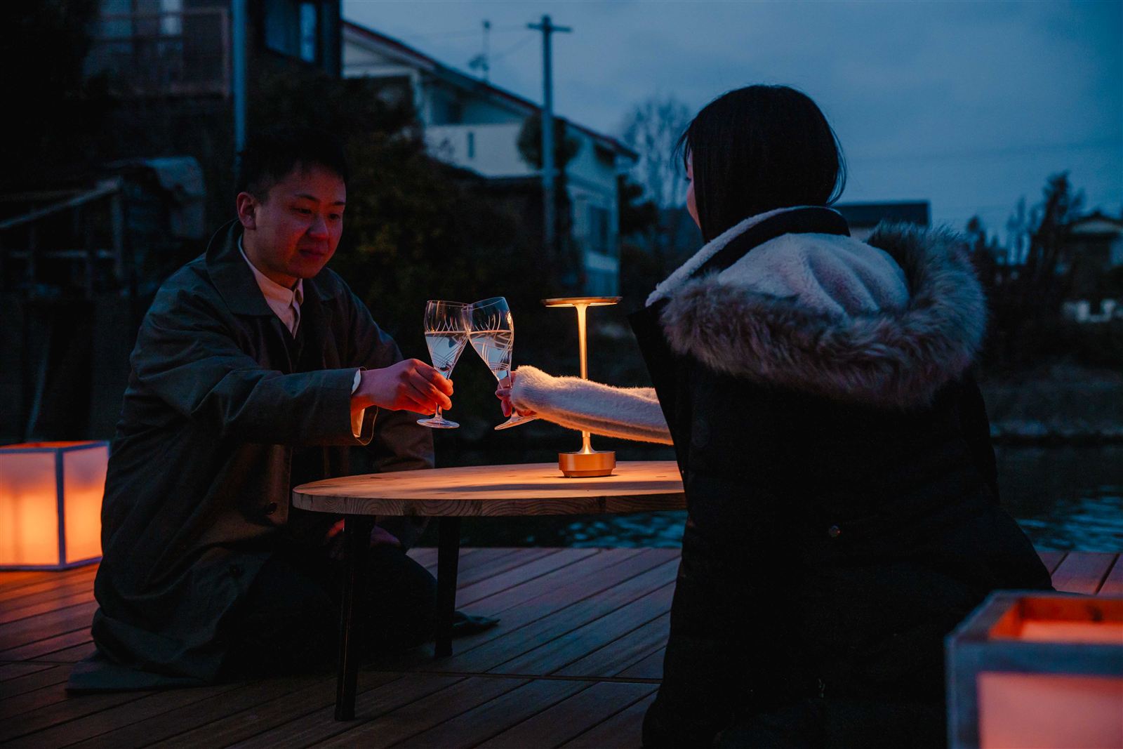 夜の掘床で乾杯するふたりと行灯